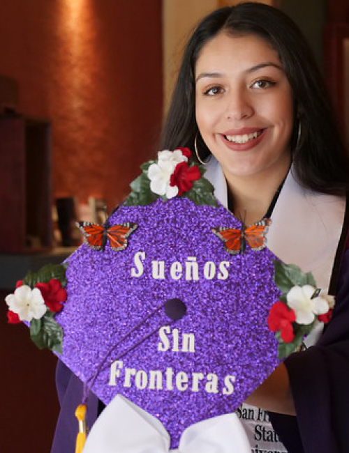 graduate student holding a decorated graduation cap